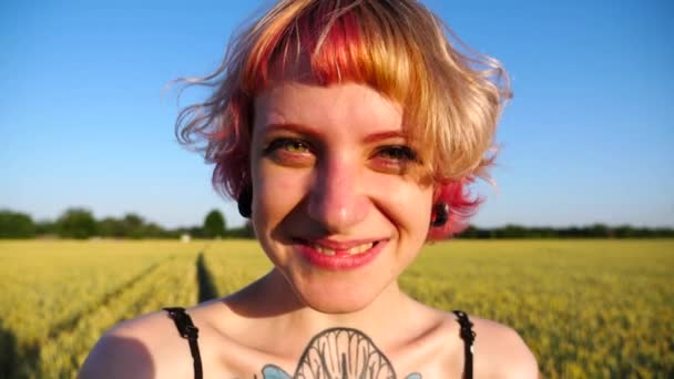 배경에 필드와 머리와 여자의 초상화 터널이있는 행복한 소녀는 초원에 서있는 — 비디오