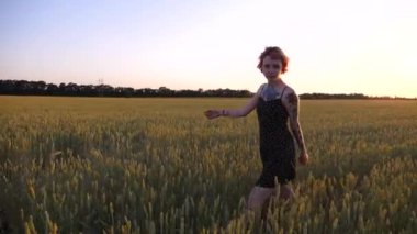 Kısa siyah elbiseli neşeli punk kızı buğday çayırlarında dolaşırken aylaklık ediyor. Dövmeli mutlu bayan hippi gün batımında yeşil arpa tarlasından geçiyor. Özgürlük kavramı.