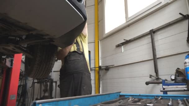 Üniformalı Bir Tamirci Atölyede Garajda Araba Arızalarını Tamir Ediyor Araba — Stok video