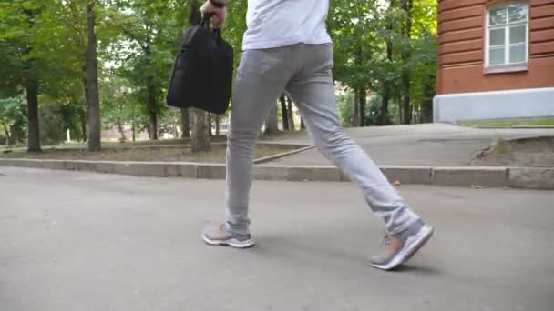 Zbliż Nogi Młodego Człowieka Luźnym Ubraniu Przechodzącego Przez Miejski Park — Wideo stockowe