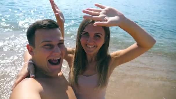 年轻的幸福夫妇在海边自画像 微笑的一对在海边做自拍 愉快的男人和女人享受蜜月假期和在海边的乐趣 休息的概念 — 图库视频影像