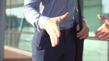 Genç meslektaşların şehir ortamında buluşup birbirlerini selamladıkları bir fotoğraf. İki başarılı iş adamı ofis binasının yakınında el sıkışıyor. Dışarıda iş tokalaşması. Yavaşça kapat..