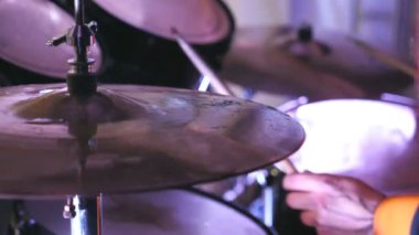 Profesyonel davulcu elleri ahşap bagetleri tutuyor ve rock konserinde davul setine vuruyor. Müzikal bir enstrümanla çalma işlemini kapat. Yan görünüm Yavaş çekim.