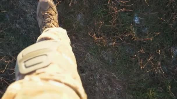 田舎の乾いた草を通って茶色のブーツで行くウクライナの兵士の女性の足への視点 未開発のフィールドの間を歩く軍事靴の若い軍隊の女の子の足 ウクライナでの戦争 — ストック動画