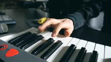 Dolly bir synthesizer ses kayıt stüdyosunda yapmaya müzisyen erkek elinde kadeh. Mens silah çalış müzik solo. Piyanist piyano tuşları, parmakları kapatın. Ağır çekim.