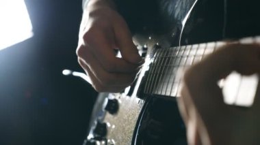 Eller erkek müzisyen elektro gitar çalmak. Mens çalış solo rock müzik silah. Dizeleri, gitarist parmakları kapatın. Stüdyoda güzel siyah arka plan. Ağır çekim yakın çekim.