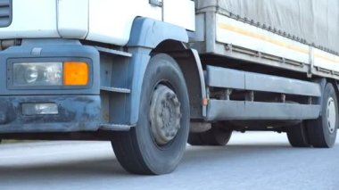 Kamera, otoyolda giden bir kamyonu takip ediyor. Kamyon kırsal kesimden geçiyor. Asfaltta kamyon gezintisi. Yan Görünümü Kapat Yavaş Çekim.