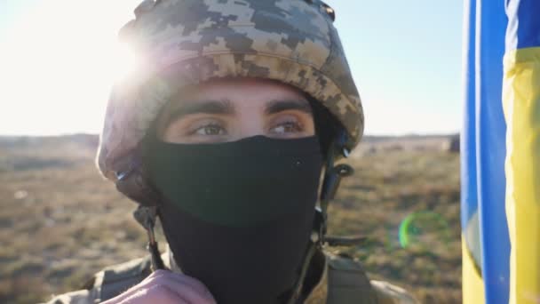 카메라 야외로 발라클라바를 시골에서 파란색 노란색 깃발을 우크라이나어 군인의 초상화 — 비디오