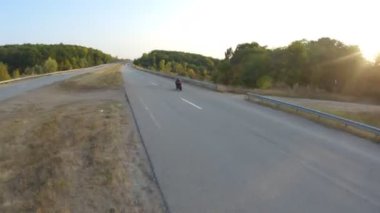 Güneşli bir sonbahar gününde otoyolda motosiklet süren bir bisikletçi. Motosikletli, kır yolunda motosikletiyle yarışıyor. Yolculuk sırasında bisiklet süren bir adam. Özgürlük ve macera kavramı. Hava görüntüsü