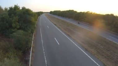 Autumn Highway 'de modern spor motosiklet kullanan motosikletlinin havadan çekilmiş fotoğrafı. Motosikletli, kır yolunda motosikletiyle yarışıyor. Yolculuk sırasında bisiklet süren adam. Yolculuktaki özgürlük ve macera kavramı.