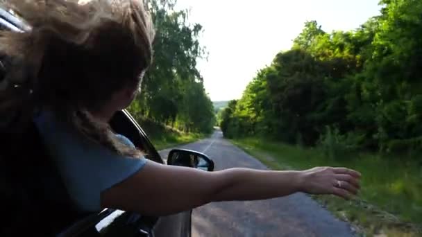 Młoda Dziewczyna Blond Włosami Wyciągająca Rękę Przez Otwarte Okno Jadąca — Wideo stockowe