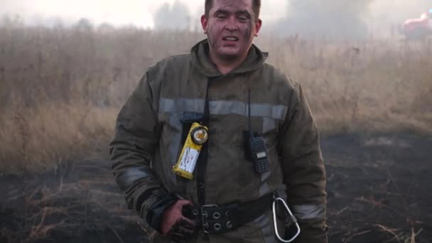 Portré Egy Fáradt Egyenruhás Tűzoltóról Füstös Pázsiton Tűz Után Egy — Stock videók