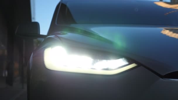 近代的な車のヘッドライトを閉じます 自動車用Ledヘッドライトの切り替え 新しい自動車ヘッドランプ 点滅ランプと車両のフロント 詳細ビュー — ストック動画