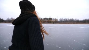Beni takip edin, güzel kızıl saçlı kadın donmuş nehirde erkek elini kayarken tutuyor. Genç kız erkek arkadaşını buz yüzeyinde paten kaymaya götürüyor. Aktif yaşam tarzları olan mutlu bir çift. POV.