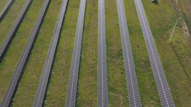 Elektrik üreten güneş paneli çiftliğinin hava görüntüsü. Enerji sıraları güneş panelleri tarım arazisi çayırlarına ya da kırsal alanlara kurulur. Ekoloji ve yenilenebilir yeşil enerji kavramı. Üst çekim.