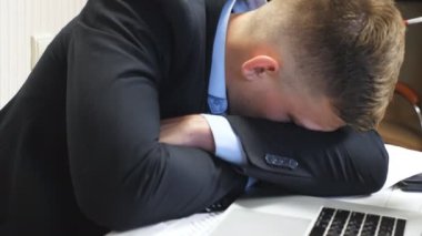 Resmi takım elbiseli patronun ofiste uyuyakalmasına çok yakınım. Genç girişimci toplantı odasında dizüstü bilgisayarla uyuyor. Yorgun yönetici iş yerinde kestiriyor. Yavaş çekim.