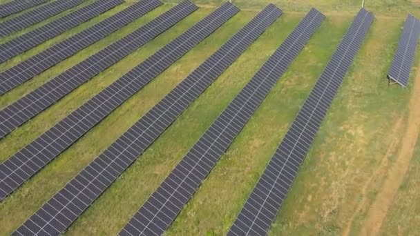 Flug Entlang Von Solarpaneelen Auf Der Grünen Wiese Solarkraftwerke Produzieren — Stockvideo