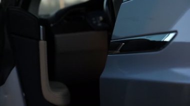 Erkek eli kapıyı açar ve modern arabaya biner. Otomobilin kapısını açmak için düğmeye basan adam. Adam otomatiğe oturuyor. Çağdaş teknolojiler kavramı. Yavaş Hareketi Kapat.