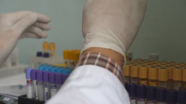 Laboratuvarda test tüpleriyle çalışan bilim adamlarının ya da doktorların eldivenli elleri. Hastane çalışanı COVID-19 'u inceliyor. Coronavirüs salgınından sağlık ve güvenlik hayatı kavramı.