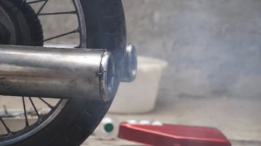 Eski motorsiklet egzoz borusunu kapatın ve havaya duman salın. Yavaş çekim.