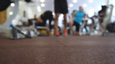 Spor malzemeleriyle antrenman yapan bir grup atletik insan. Genç sporcular ve sporcu kadınlar spor salonunda çalışıyor. Bulanık hareket. Sağlıklı ve aktif yaşam tarzı kavramı. Düşük görünüm.
