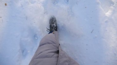 Kadın bacaklarının derin kara basıp tekmeleyişinin en üst görüntüsü. Soğuk kış gününde, kar ormanlarında yürüyen tanınmayan bir yürüyüşçü. Kız dışarı çıkıyor. POV Yavaş çekim Kapat.