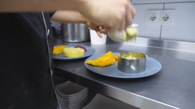 Aşçının erkek eli mutfaktaki demir kalıba kaşıkla püre koyuyor. Şef patates püresi ve tavuklu fileto servis ediyor. Yemek hazırlama kavramı. Yavaşça kapat..