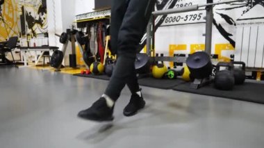 Spor kulübünde atlama halatıyla atlayan bir erkek ayak sporcusu. Spor salonunda egzersiz yapan genç sporcuların bacakları. Spor giyimli sporcu adam spor kulübünde kardiyo yapıyor. Etkin yaşam biçimi kavramı.