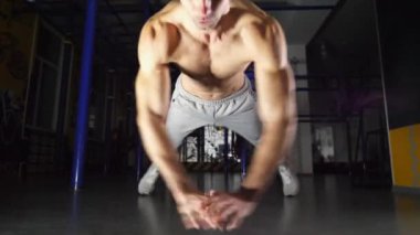 Kaslı sporcu modern spor salonunda itme hareketi yapıyor. Genç sporcu sıkı ve yoğun idman yapıyor. Spor salonunda spor yapan güçlü bir adam. Sağlıklı ve aktif yaşam tarzı kavramı. Yavaşça kapat.