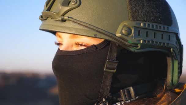 穿着头盔和巴拉克拉瓦的女兵的凝视 年轻的女军人在日落时满怀希望地凝视着自己的形象 抵抗入侵 俄罗斯和乌克兰之间的战争 靠近点 — 图库视频影像