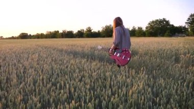 Uzun saçlı, elektro gitarı elinde tutan ve buğday tarlasında yürüyen genç bir hippi. Müzik enstrümanlı hippi adam yeşil arpa çayırlarında dolaşıyor ve gün batımında doğanın tadını çıkarıyor..