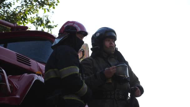 Tűzoltóparancsnok Beszélt Beosztottjával Munkáról Egy Tűzoltóautó Hátterében Fiatal Profi Tűzoltók — Stock videók