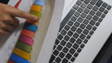 Genç iş arkadaşlarının erkek ve kadın ellerine en iyi bakış açısı. Satış grafikleri ve çizelgeleri ofiste inceleniyor. Profesyonel yöneticilerden oluşan bir grup masada oturan mali raporları inceliyor. Dolly vurdu..