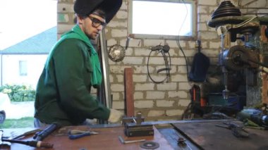 Atölyede çalışırken koruyucu gözlüklü, komik dans eden mutlu adam. Erkek tamirci iş yerinde aylaklık ediyor. Üniformalı neşeli tamirci garajda eğleniyor ve eğleniyor. Yavaş çekim.