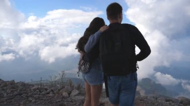Dağ başında duran ve güzel manzaraya bakarak turist genç çift onlara iletin. Erkek ve kadın manzarayı Kanyon kenarına aşık. Yavaş hareket kapatmak.