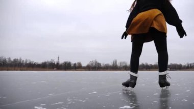 Genç sporcu kadın dışarıda idman yaparken buz pateni sahasına düşüyor. Buz nehrinde buz pateni antrenmanı yapan kadın patenci. Dondurucu kış gününde aktif eğlence. Sağlıklı yaşam tarzı kavramı