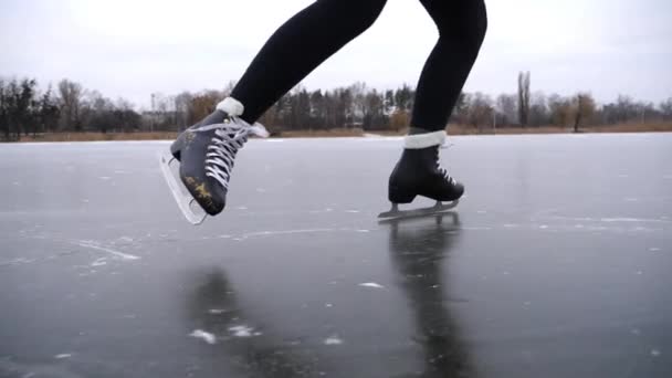 穿着花样滑冰的女人的腿在大自然的冰上滑行 在冰冻的河流或湖上滑冰的女足 在冬天寒冷的天气里 年轻姑娘有积极的闲暇时间 慢动作 — 图库视频影像
