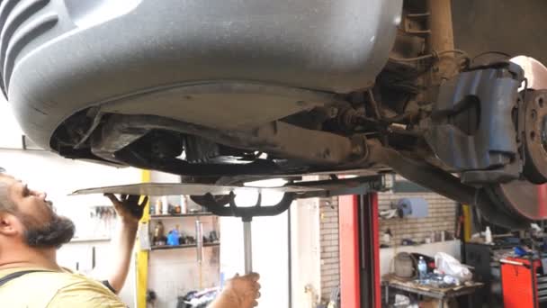 Reparador Barbudo Que Instala Proteção Motor Carro Com Ferramenta Especial — Vídeo de Stock