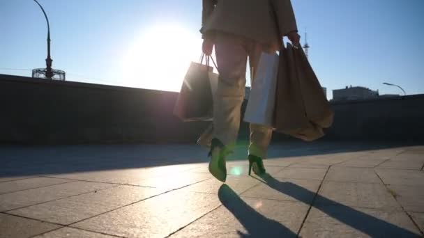 Young Beautiful Woman Holds Shopping Bags Walking Sunny City Street — стоковое видео