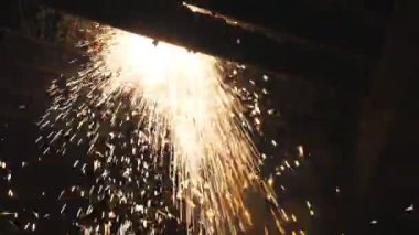 Birçok parlak kıvılcım plazma kesimi sırasında sıcak metalden uçar. Lazer kesici çalışıyor. Endüstriyel metal üretimi. Çelikten bir eser üretmek. Atölyede detayları anlatıyorum. Yavaş çekim.