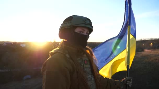 군복을 여자는 일몰에 대하여 우크라이나의 국기를 들었다 우크라이나 흔들리는 깃발을 — 비디오