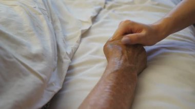 Kız, klinikte hasta ve olgun bir kadının elini tutup rahatlatıyor. Torunu yatakta yatan büyükannesinin kırışık koluna nazikçe dokunuyor. Kızı annesine ilgi ve sevgi gösteriyor..