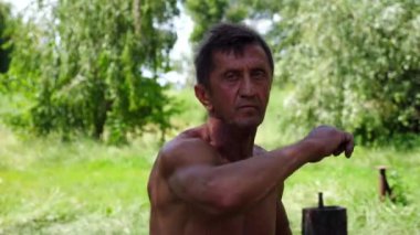 Yetişkin erkek sporcu, Wing Chun kung fu 'sunu açık havada gösteriyor. Yaşlı adam yaz günü dövüş teknikleri uyguluyor. Yaşlı sporcu dövüş sanatları eğitimi alıyor. Sportif yaşam tarzı kavramı. Yavaş çekim.