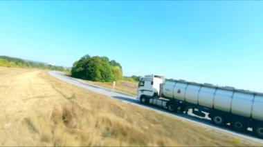 Kargo karavanıyla birlikte yolda giderken ve malları taşırken çekilen hava görüntüsü. Taşra otobanı boyunca giden teslimat kamyonunun üzerinde uçuyor. Endüstriyel araba hedefe gidiyor. Lojistik kavram