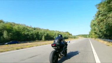 Yaz günü otoyolda hızlı giden bir adamın havadan çekilmiş fotoğrafı. Motosikletli, kır yolunda motosikletiyle yarışıyor. Yolculuk sırasında bisiklet süren bir adam. Özgürlük ve macera kavramı.