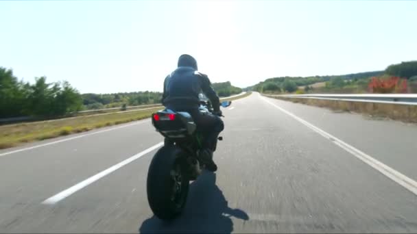 バイカーは夏の旅行中にバイクを運転しています 高速道路で近代的なスポーツバイクに乗る男 オートバイは自転車を国道で走らせている 冒険の概念について アリアルショット — ストック動画