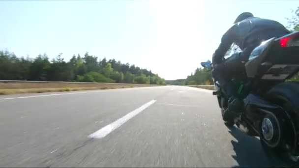 夏の日に高速道路でモダンなスポーツバイクに乗っている男性の空中撮影 モーターサイクリストは 国道でバイクをレースします 旅行中に自転車を運転する 自由と冒険の概念 — ストック動画