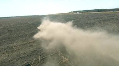 Tarımsal tarım arazisinde tarla sürme sistemi olan traktörün hava görüntüsü. Arkasındaki toz parçalarıyla hasat edildikten sonra tarlayı işliyor. Tarım makinesi tarım arazisinden geçiyor.