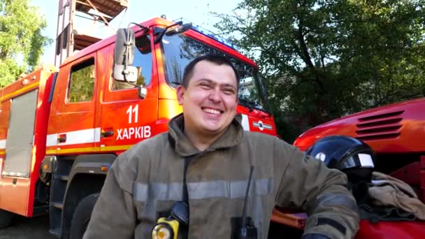 Portret Szczęśliwego Młodego Fireguarda Mundurze Tle Wozu Strażackiego Mężczyzna Strażak — Wideo stockowe