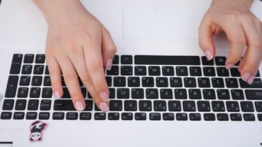 Dizüstü bilgisayarın üst görüntüsü ve yazı yazan kadın elleri. Dışarıda defter kullanan tanınmayan bir kadın. Yeni bir proje üzerinde çalışan yaratıcı bir serbest yazar. Arka plan bulanık. Yavaş çekim. Yakın çekim..